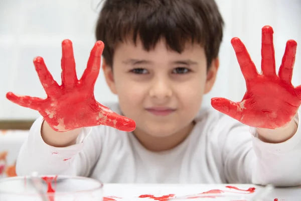 Großaufnahme kleiner Junge beim Malen mit bunten Händen. Kunst, Kreativität und Malkonzept — Stockfoto