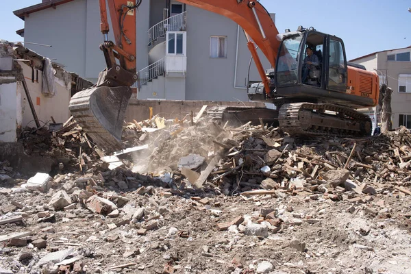 Urla, Turquía - 13 de mayo de 2020: excavadora cargando escombros de un edificio destruido en camión . —  Fotos de Stock