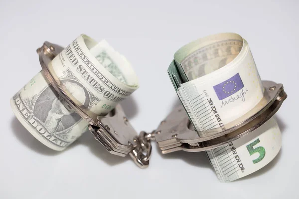 Счета по доллару и евро с наручниками. — стоковое фото