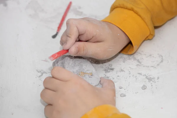 Image of an educational game to find fossils for a small archaeologist, with childrens hands digging — Stock Photo, Image