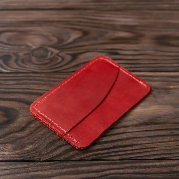 Red colour handmade leather one pocket cardholder on wooden back