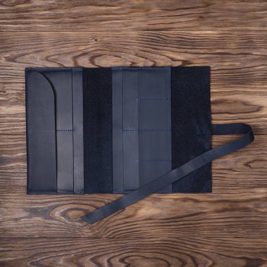 Siyah el yapımı seyahat cüzdanı desenli ahşap arka planda yatıyor. Fotoğrafta cüzdanı aç. Görüş açımız düşük. İşadamı aksesuarlarının resmi..