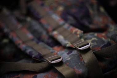 Askeri kamuflaj oda gibi sırt çantası. Kayışın çerçevesinde ve sırt çantasının arkasında. Yakın çekim görünümü.