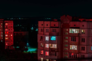 Kırmızı ve mavi ışıklı yüksek binaların uzun pozlu fotoğrafı. Gece manzarası. Büyük şehir hayatı.