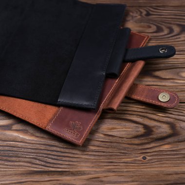 Ukrayna, Kyiv, 20.02.2019 Iki el yapımı deri dizüstü ahşap arka planda kapsar. Yan görünüm. Kapaklar açık ve boştur. Yalnızca editoryal kullanım.