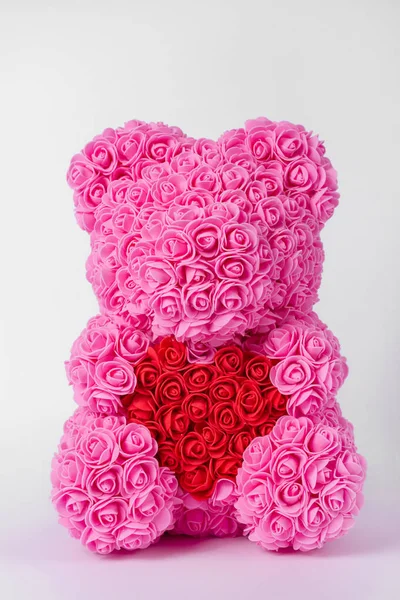 Розовый плюшевый медвежонок из пенных роз. Красное сердце в плюшевых лапах . — стоковое фото
