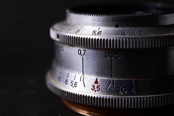 Old vintage lens scales symbols closeup. Photo with blurred gray