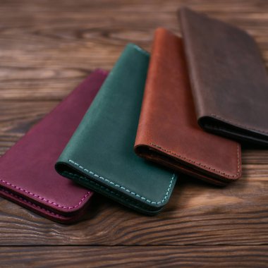 Ahşap desenli arka planda dört adet el yapımı deri portatif montaj. Yan görüş. Lüks aksesuarların stok fotoğrafı.