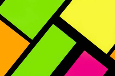 Siyah kağıda yeşil, sarı, turuncu ve mor renkli ofis etiketleri yapıştırdım. Hatırlatmak için ofis noteri. Siyah kağıda izole edilmiş..