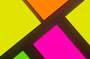 Siyah kağıda yeşil, sarı, turuncu ve mor renkli ofis etiketleri yapıştırdım. Hatırlatmak için ofis noteri. Siyah kağıda izole edilmiş..