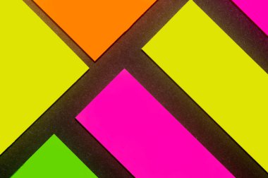 Siyah kağıda yeşil, sarı, turuncu ve mor renkli ofis etiketleri yapıştırdım. Hatırlatmak için ofis noteri. Siyah kağıda izole edilmiş..