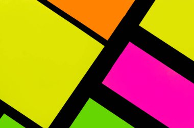 Siyah kağıda yeşil, sarı, turuncu ve mor renkli ofis etiketleri yapıştırdım. Hatırlatmak için ofis noteri. Siyah kağıda izole edilmiş..