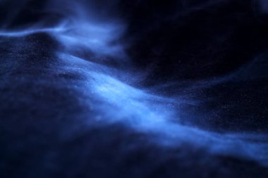 Siyah kumaş arka planda beyaz duman. Duman arka planda yayılıyor. Kültür buharlaştırma, sigarasız yaşam. Kavramsal resim.