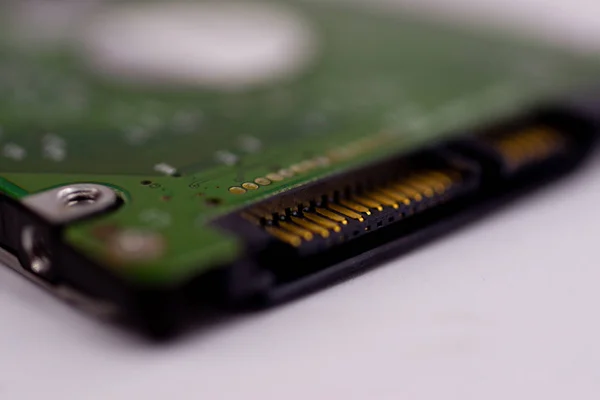 2.5mm laptop HDD on white blurred background. A lot of space on photo is defocused or have soft focus.