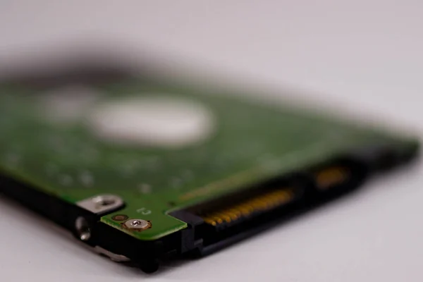 2.5mm laptop HDD on white blurred background. A lot of space on photo is defocused or have soft focus.