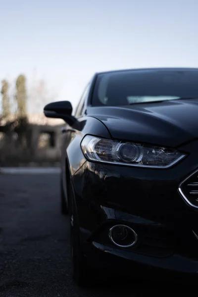 Modern car headlamps shot. Nice car eyes. Half of car on photo, blurred background. Cose up view. Aggressive car eyes.