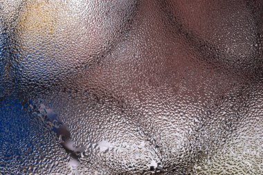 Cam pencereye su damlaları düşer. Arka planda bulanıklık olur. Makroda damlalar. Pencereye yakın mesafede yoğunlaş. Islak hava.