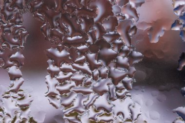 Cam pencereye su damlaları düşer. Arka planda bulanıklık olur. Makroda damlalar. Pencereye yakın mesafede yoğunlaş. Islak hava.