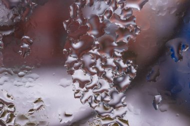 Cam pencereye su damlaları düşer. Arka planda bulanıklık olur. Makroda damlalar. Pencereye yakın mesafede yoğunlaş. Islak hava.