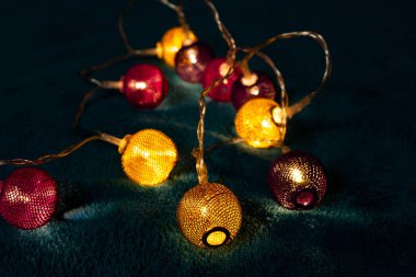 Mavi battaniyenin üzerinde metalik ızgara topları olan bir pil çelengi. Bulanık arkaplan ile yakın plan görünümü.