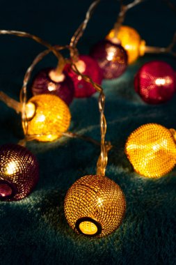 Mavi battaniyenin üzerinde metalik ızgara topları olan bir pil çelengi. Bulanık arkaplan ile yakın plan görünümü.