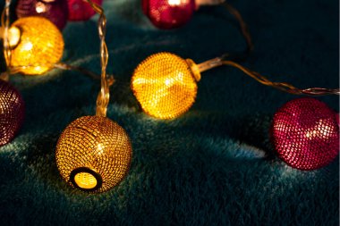 Mavi battaniyenin üzerinde metalik ızgara topları olan bir pil çelengi. Bulanık arkaplan ile yakın plan görünümü.