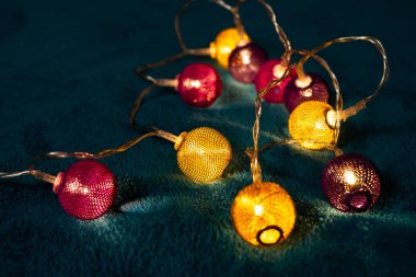 Mavi battaniyenin üzerinde metalik ızgara topları olan bir pil çelengi. Bulanık arkaplan ile yakın plan görünümü.