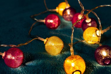 Mavi battaniyenin üzerinde metalik ızgara topları olan bir pil çelengi. Bulanık arkaplan ile yakın plan görünümü.