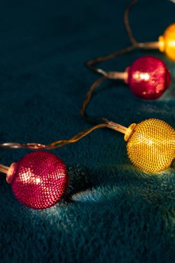 Mavi battaniyenin üzerinde metalik ızgara topları olan bir pil çelengi. Bulanık arkaplan ile yakın plan görünümü.