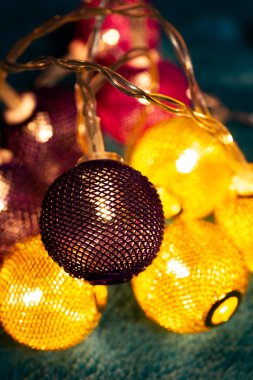 Mavi battaniyenin üzerinde metalik ızgara topları olan bir pil çelengi. Bulanık arkaplan ile yakın plan görünümü.