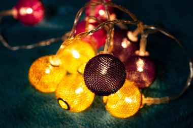 Mavi battaniyenin üzerinde metalik ızgara topları olan bir pil çelengi. Bulanık arkaplan ile yakın plan görünümü.