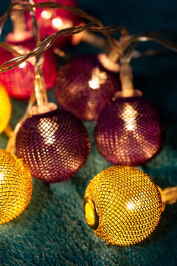 Mavi battaniyenin üzerinde metalik ızgara topları olan bir pil çelengi. Bulanık arkaplan ile yakın plan görünümü.