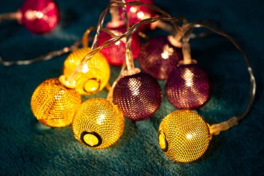 Mavi battaniyenin üzerinde metalik ızgara topları olan bir pil çelengi. Bulanık arkaplan ile yakın plan görünümü.