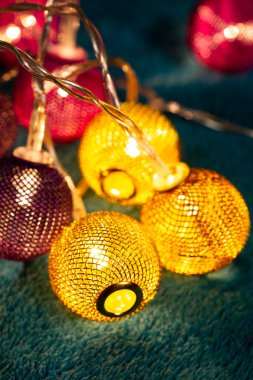 Mavi battaniyenin üzerinde metalik ızgara topları olan bir pil çelengi. Bulanık arkaplan ile yakın plan görünümü.