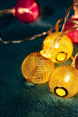 Mavi battaniyenin üzerinde metalik ızgara topları olan bir pil çelengi. Bulanık arkaplan ile yakın plan görünümü.