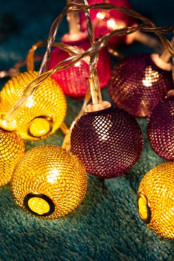 Mavi battaniyenin üzerinde metalik ızgara topları olan bir pil çelengi. Bulanık arkaplan ile yakın plan görünümü.