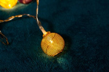 Mavi battaniyenin üzerinde metalik ızgara topları olan bir pil çelengi. Bulanık arkaplan ile yakın plan görünümü.