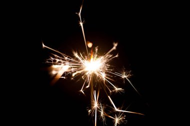 Bengali yangınının düşük ışıkta çekilmiş fotoğrafı siyah arka planda izole edilmiş. Bir sürü ışık ve kıvılcım. Görünmeyen fotoğraf.