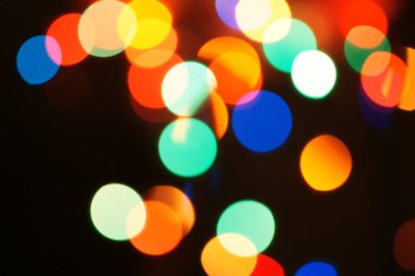 Çok renkli bayram çelengi. Çelenk bulanık. Bir sürü renkli yuvarlak ışık. Tamamen odaklanmış bir fotoğraf. Arka plan ve ön plan bulanık. Tatil havası. Yeni yıl ve Noel yaklaşıyor..