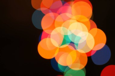 Çok renkli bayram çelengi. Çelenk bulanık. Bir sürü renkli yuvarlak ışık. Tamamen odaklanmış bir fotoğraf. Arka plan ve ön plan bulanık. Tatil havası. Yeni yıl ve Noel yaklaşıyor..