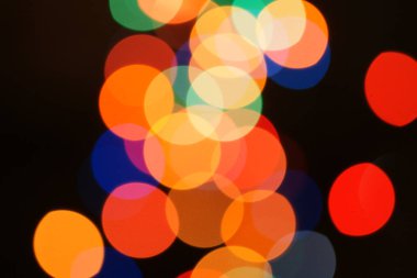 Çok renkli bayram çelengi. Çelenk bulanık. Bir sürü renkli yuvarlak ışık. Tamamen odaklanmış bir fotoğraf. Arka plan ve ön plan bulanık. Tatil havası. Yeni yıl ve Noel yaklaşıyor..