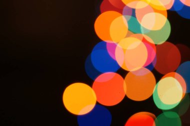 Çok renkli bayram çelengi. Çelenk bulanık. Bir sürü renkli yuvarlak ışık. Tamamen odaklanmış bir fotoğraf. Arka plan ve ön plan bulanık. Tatil havası. Yeni yıl ve Noel yaklaşıyor..