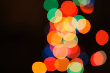 Çok renkli bayram çelengi. Çelenk bulanık. Bir sürü renkli yuvarlak ışık. Tamamen odaklanmış bir fotoğraf. Arka plan ve ön plan bulanık. Tatil havası. Yeni yıl ve Noel yaklaşıyor..