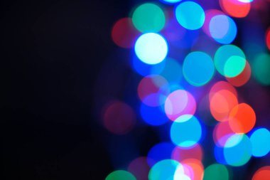 Çok renkli mavi tatil çelengi. Çelenk bulanık. Bir sürü renkli yuvarlak ışık. Tamamen odaklanmış bir fotoğraf. Arka plan ve ön plan bulanık. Tatil havası. Yeni yıl ve Noel yaklaşıyor..