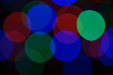 Çok renkli mavi tatil çelengi. Çelenk bulanık. Bir sürü renkli yuvarlak ışık. Tamamen odaklanmış bir fotoğraf. Arka plan ve ön plan bulanık. Tatil havası. Yeni yıl ve Noel yaklaşıyor..