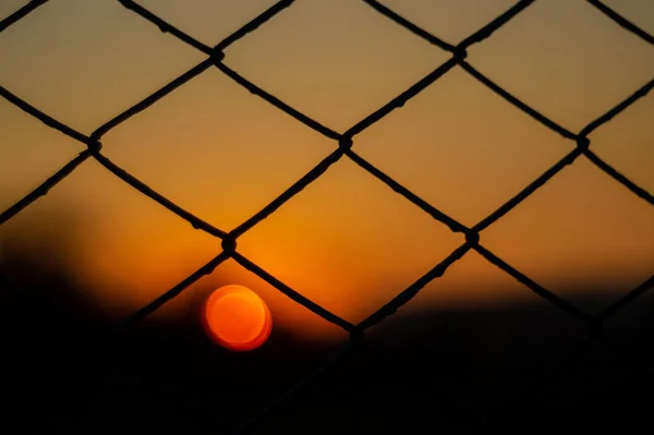 Оранжевое Вечернее Небо Размытым Солнцем Заборе Творческая Идея Недоэкспонированное Фото — стоковое фото