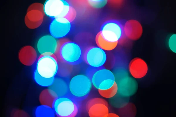 マルチカラーブルーのホリデーガーランド ガーランドはぼやけている 多くの大きなカラフルなラウンドライト 完全に焦点を絞った写真 背景と前景がぼやけています 休日の気分 新年とクリスマスが近づいています — ストック写真