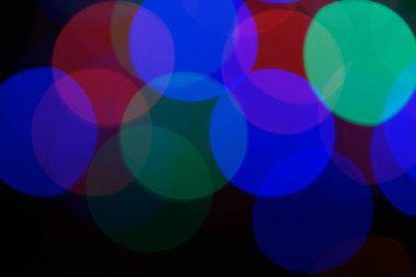 Çok renkli mavi tatil çelengi. Çelenk bulanık. Bir sürü renkli yuvarlak ışık. Tamamen odaklanmış bir fotoğraf. Arka plan ve ön plan bulanık. Tatil havası. Yeni yıl ve Noel yaklaşıyor..