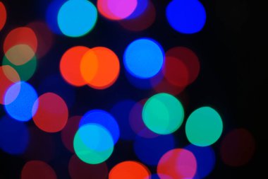 Çok renkli mavi tatil çelengi. Çelenk bulanık. Bir sürü renkli yuvarlak ışık. Tamamen odaklanmış bir fotoğraf. Arka plan ve ön plan bulanık. Tatil havası. Yeni yıl ve Noel yaklaşıyor..