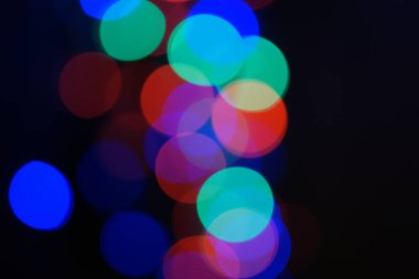 Çok renkli mavi tatil çelengi. Çelenk bulanık. Bir sürü renkli yuvarlak ışık. Tamamen odaklanmış bir fotoğraf. Arka plan ve ön plan bulanık. Tatil havası. Yeni yıl ve Noel yaklaşıyor..